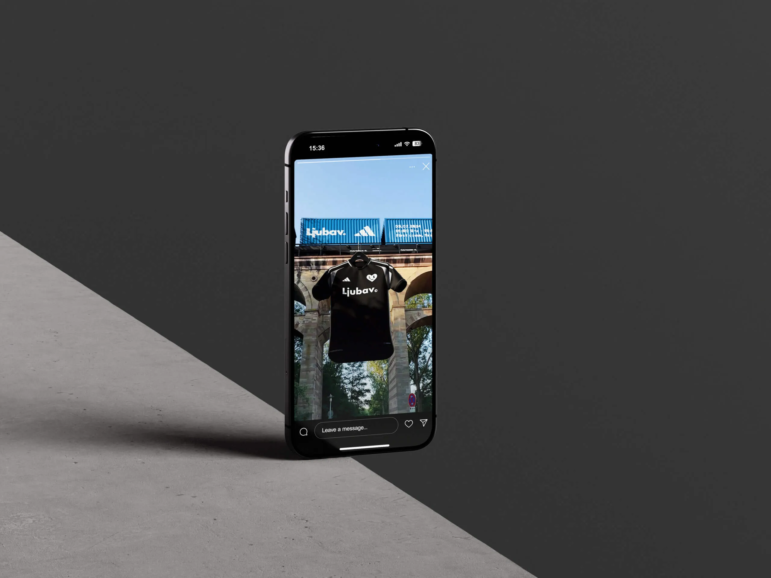 Smartphone an einer grauen Kante, auf dem Display das Adidas-×-Ljubav-Trikot