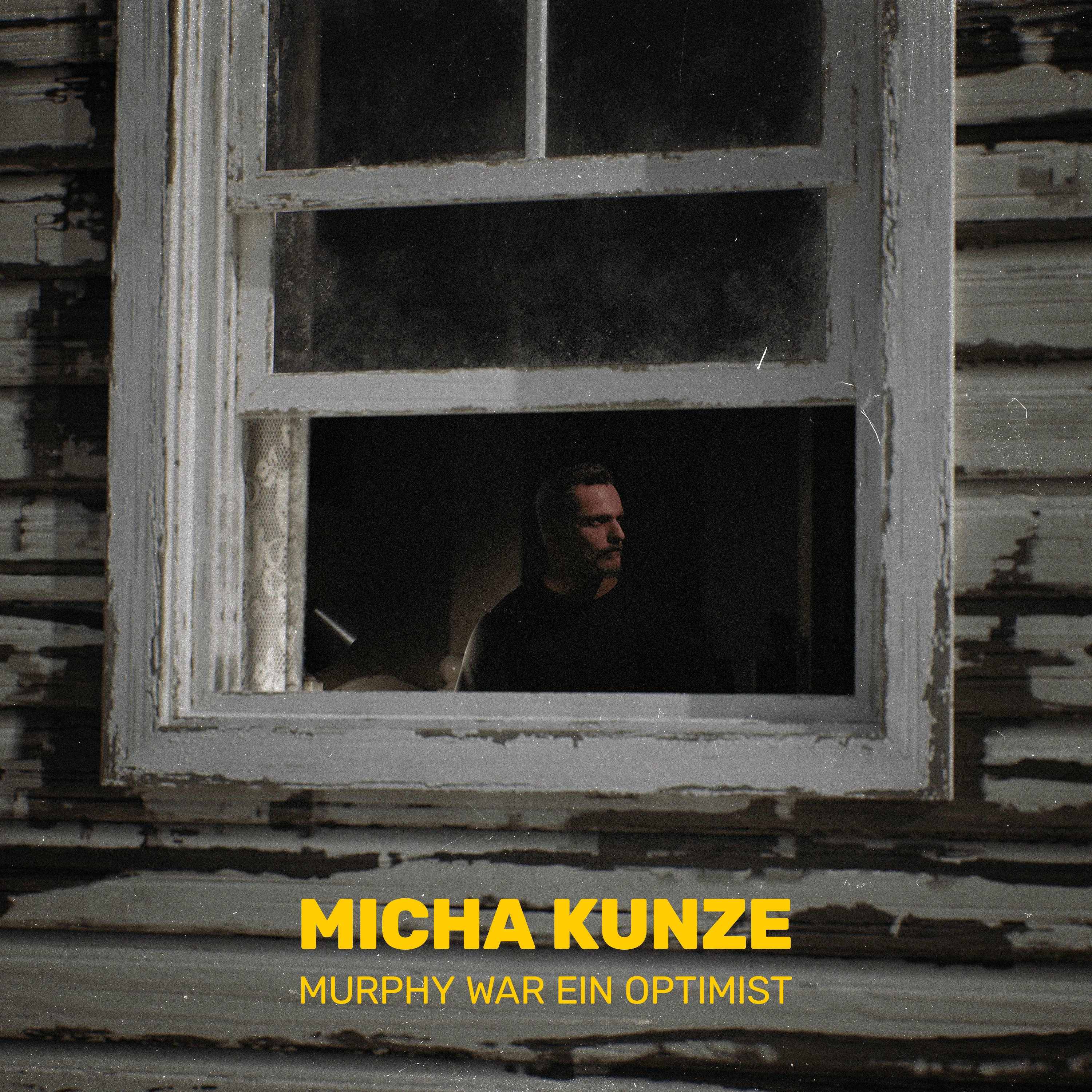Cover: Micha Kunze hinter einem alten Holzfenster, darunter der Titel in Gelb